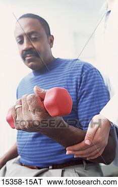 Stock Photo - middle-aged man 
lifting hand weights 
during physical 
therapy session. 
fotosearch - search 
stock photos, 
pictures, images, 
and photo clipart