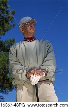Stock Photo - mature male golfer 
standing with 
club,  on property 
released golf. 
fotosearch - search 
stock photos, 
pictures, images, 
and photo clipart