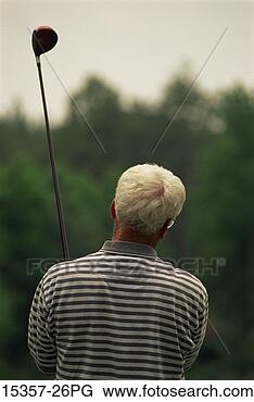 Stock Photo - rear view of male 
golfer holding 
up golf club (wood) 
after teeing off. 
fotosearch - search 
stock photos, 
pictures, images, 
and photo clipart