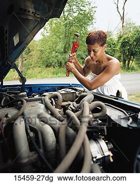 Stock Photo - woman with car 
trouble, holding 
wrench. fotosearch 
- search stock 
photos, pictures, 
images, and photo 
clipart