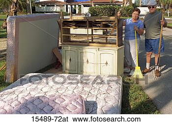 Stock Photo - hurricane storm 
damage cleanup; 
mature couple 
- yard tools - 
debris -. fotosearch 
- search stock 
photos, pictures, 
images, and photo 
clipart