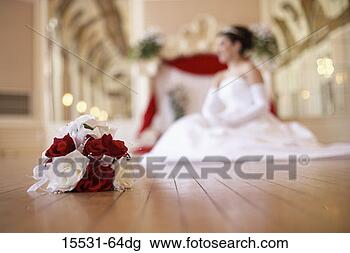 Stock Photo - bride sitting 
on floor with 
bouquet in the 
foreground. fotosearch 
- search stock 
photos, pictures, 
images, and photo 
clipart