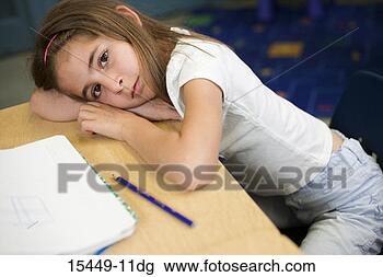Stock Photo - girl with head 
down on desk in 
classroom. fotosearch 
- search stock 
photos, pictures, 
images, and photo 
clipart