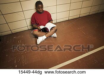 Stock Photo - student sitting 
on floor with 
book. fotosearch 
- search stock 
photos, pictures, 
images, and photo 
clipart