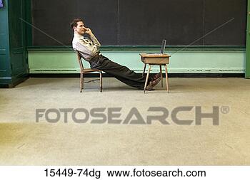Stock Photo - teacher sitting 
at student desk 
using cellphone. 
fotosearch - search 
stock photos, 
pictures, images, 
and photo clipart