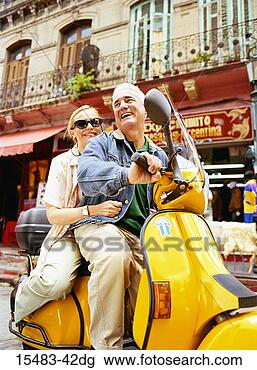 Stock Photo - close-up of older 
man and woman 
riding scooter 
in buenos aires. 
fotosearch - search 
stock photos, 
pictures, images, 
and photo clipart