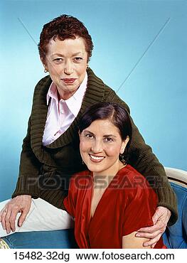 Banco de Imagem - dois,  latinas, 
 sorrindo,  um, 
 sentando,  outro, 
 atrás de. fotosearch 
- busca de fotos, 
imagens e clipart
