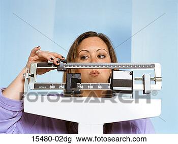 Stock Photo - plus-sized woman 
standing at scale 
moving slider. 
fotosearch - search 
stock photos, 
pictures, images, 
and photo clipart