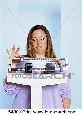 Stock Photo - plus-sized woman 
standing on scale, 
looking unhappy. 
fotosearch - search 
stock photos, 
pictures, images, 
and photo clipart