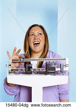 Stock Photo - plus-sized woman 
standing on scale, 
smiling. fotosearch 
- search stock 
photos, pictures, 
images, and photo 
clipart