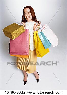 Stock Photo - plus-sized woman 
standing, holding 
many shopping 
bags, smiling. 
fotosearch - search 
stock photos, 
pictures, images, 
and photo clipart