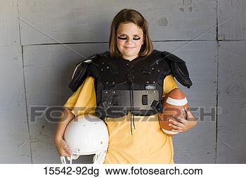 Stock Photo - girl in football 
pads holding football 
and helmet. fotosearch 
- search stock 
photos, pictures, 
images, and photo 
clipart