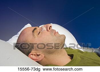 Stock Photo - man asleep wearing 
a nasal breathing 
strip. fotosearch 
- search stock 
photos, pictures, 
images, and photo 
clipart