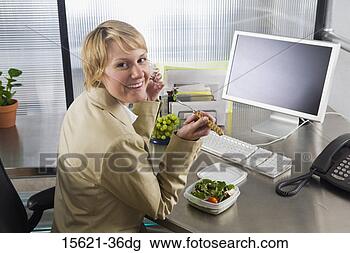 Stock Photo - businesswoman 
eating at desk. 
fotosearch - search 
stock photos, 
pictures, images, 
and photo clipart