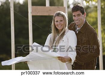 Picture - couple on home 
construction site 
with blueprints, 
portrait. fotosearch 
- search stock 
photos, pictures, 
images, and photo 
clipart