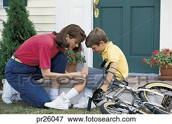 Picture - mother fixing 
child's skinned 
knee from bike. 
fotosearch - search 
stock photos, 
pictures, images, 
and photo clipart