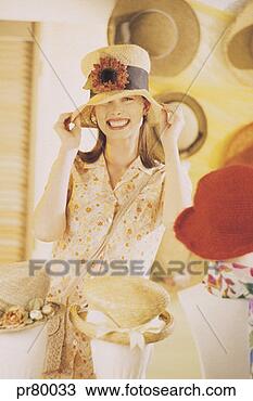 Stock Photo - caucasian woman 
trying on hats 
in a hat store/department. 
fotosearch - search 
stock photos, 
pictures, images, 
and photo clipart