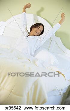 Stock Photo - woman stretching 
in bed. fotosearch 
- search stock 
photos, pictures, 
images, and photo 
clipart
