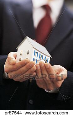 Stock Photo - businessman holding 
model house. fotosearch 
- search stock 
photos, pictures, 
images, and photo 
clipart