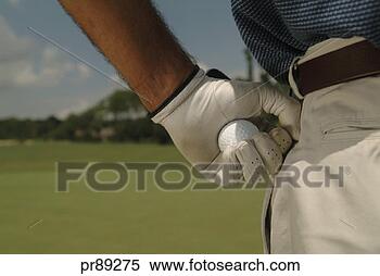 Stock Image - man on golf course 
holding golf ball. 
fotosearch - search 
stock photos, 
pictures, images, 
and photo clipart