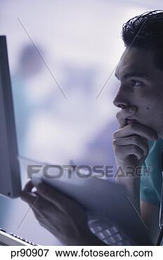 Picture - doctor holding 
patient chart 
and looking at 
computer screen. 
fotosearch - search 
stock photos, 
pictures, images, 
and photo clipart