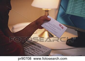 Stock Photo - man at computer 
holding past due 
notice. fotosearch 
- search stock 
photos, pictures, 
images, and photo 
clipart