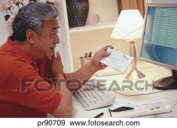 Stock Photograph - man at computer 
holding past due 
notice. fotosearch 
- search stock 
photos, pictures, 
images, and photo 
clipart