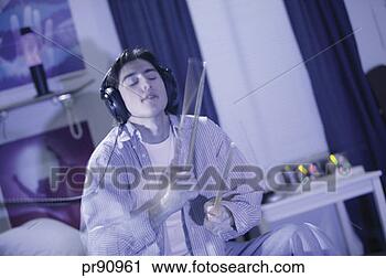 Stock Photography - teenager holding 
drum sticks and 
listening to music. 
fotosearch - search 
stock photos, 
pictures, images, 
and photo clipart
