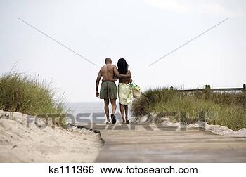 Stock Photo - couple walking 
near the beach, 
rear view. fotosearch 
- search stock 
photos, pictures, 
images, and photo 
clipart