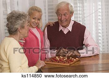 Stock Photography - grandparents playing 
checkers with 
granddaughter. 
fotosearch - search 
stock photos, 
pictures, images, 
and photo clipart