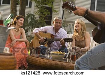 Stock Photo - group of people 
conversing and 
playing guitar 
at a party. fotosearch 
- search stock 
photos, pictures, 
images, and photo 
clipart
