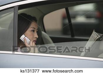 Foto - executiva,  montando, 
 car,  enquanto, 
 falando,  célula, 
 telefone. fotosearch 
- busca de fotos, 
imagens e clipart