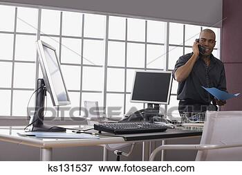 Picture - businessman on 
phone at desk. 
fotosearch - search 
stock photos, 
pictures, images, 
and photo clipart