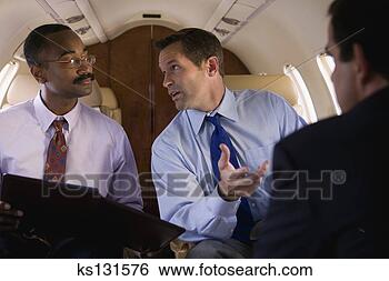 Stock Photo - businessmen chatting 
in airplane. fotosearch 
- search stock 
photos, pictures, 
images, and photo 
clipart
