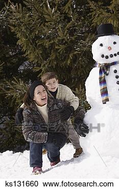 Stock Photography - mother and son 
crouching next 
to snowman. fotosearch 
- search stock 
photos, pictures, 
images, and photo 
clipart