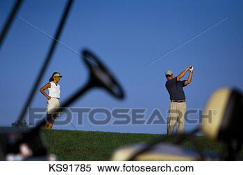 Stock Image - couple playing 
golf, golf cart 
in foreground. 
fotosearch - search 
stock photos, 
pictures, images, 
and photo clipart
