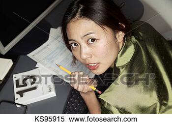 Stock Image - woman completing 
her tax form, 
shot from above, 
portrait. fotosearch 
- search stock 
photos, pictures, 
images, and photo 
clipart