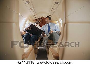 Stock Photo - two businessmen 
reading on private 
plane. fotosearch 
- search stock 
photos, pictures, 
images, and photo 
clipart