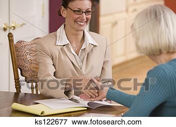 Picture - businesswoman 
shaking hands 
and reviewing 
paperwork with 
elderly woman. 
fotosearch - search 
stock photos, 
pictures, images, 
and photo clipart