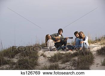 Arquivo Fotográficos - adolescentes, 
 escutar,  guitarra, 
 praia. fotosearch 
- busca de fotos, 
imagens e clipart