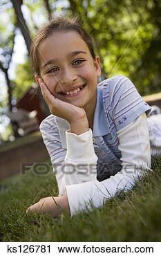 Arquivo de Fotografia - menina,  mentindo, 
 capim. fotosearch 
- busca de fotos, 
imagens e clipart