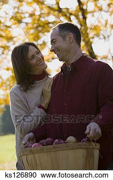 Stock Photography - couple in orchard 
with basket of 
apples. fotosearch 
- search stock 
photos, pictures, 
images, and photo 
clipart