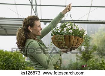 Stock Photo - woman holding 
hanging plant. 
fotosearch - search 
stock photos, 
pictures, images, 
and photo clipart