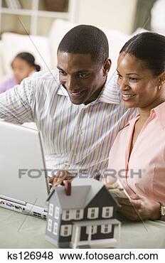 Banco de Imagem - par,  usando, 
 laptop,  junto, 
 modelo,  casa, 
 perto. fotosearch 
- busca de fotos, 
imagens e clipart