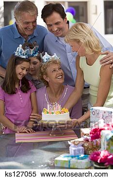 Stock Image - family presenting 
grandmother with 
birthday cake. 
fotosearch - search 
stock photos, 
pictures, images, 
and photo clipart