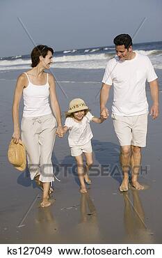 Stock Photograph - parents walking 
with daughter 
on beach. fotosearch 
- search stock 
photos, pictures, 
images, and photo 
clipart