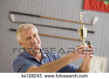 Stock Photo - man holding golfing 
trophy. fotosearch 
- search stock 
photos, pictures, 
images, and photo 
clipart
