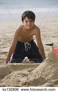 Stock Photo - smiling boy making 
sand castle at 
beach. fotosearch 
- search stock 
photos, pictures, 
images, and photo 
clipart