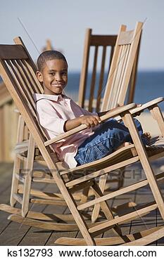 Banco de Imagem - sorrindo,  menino, 
 sentando,  cadeira. 
fotosearch - busca 
de fotos, imagens 
e clipart