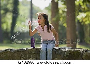 Arquivo de Fotografias - menina,  soprando, 
 bolhas. fotosearch 
- busca de fotos, 
imagens e clipart